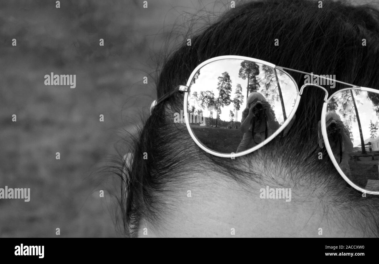 Modische tropfenförmige Sonnenbrille auf der Stirn mit Reflexion der Fotograf Stockfoto