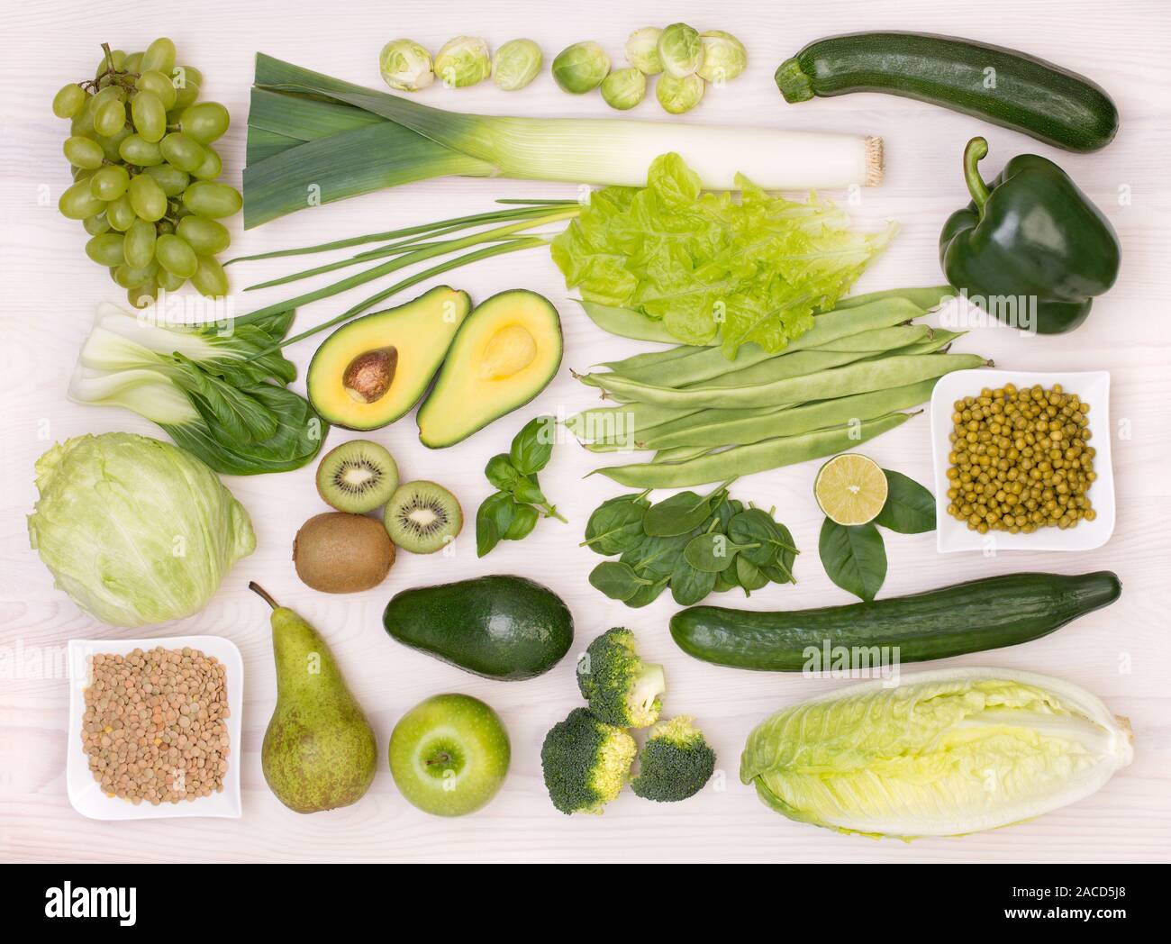 Auswahl an grünem Obst und Gemüse, Draufsicht auf einem Holztisch Stockfoto