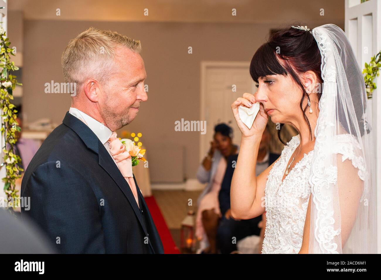 Eine Braut weint, während sie drinnen bei einer traditionellen englischen Hochzeitszeremonie im Manor, B&B, Hotel in Cheadle Stoke in Trent Staffordshire heiratet Stockfoto