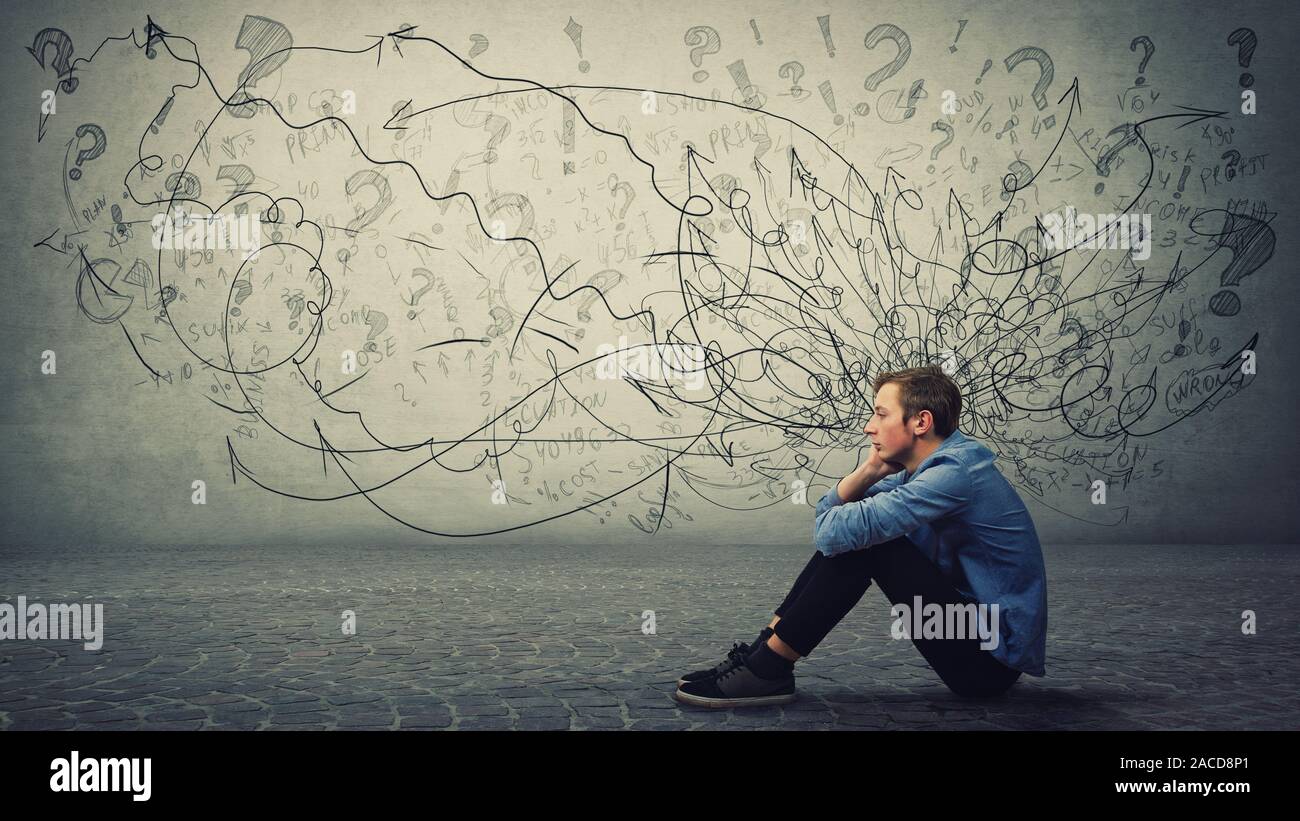 Aufgeregt und müde junge Teenager sitzen auf dem Boden Hand hält sich die Wange nachdenklich und hoffnungslos. Betonte student Guy fühlt sich emotional discomfo Stockfoto