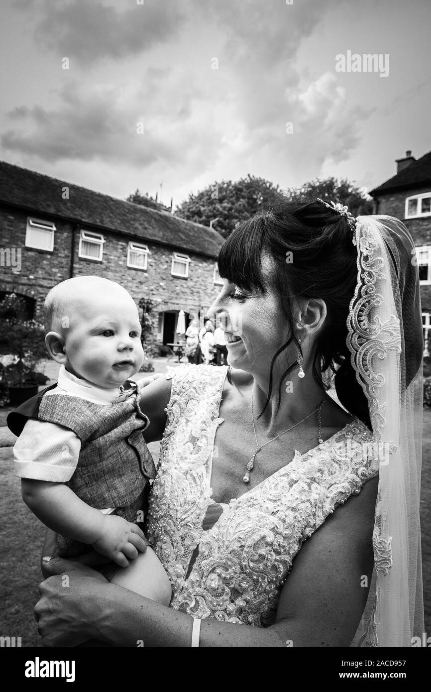 Eine Braut, Mutter posiert mit ihrem kleinen Jungen, nachdem sie geheiratet hat in The Manor Gardens, Hotel, B&B in Cheadle, Stoke on Trent, Staffordshire, Hochzeitstag Stockfoto