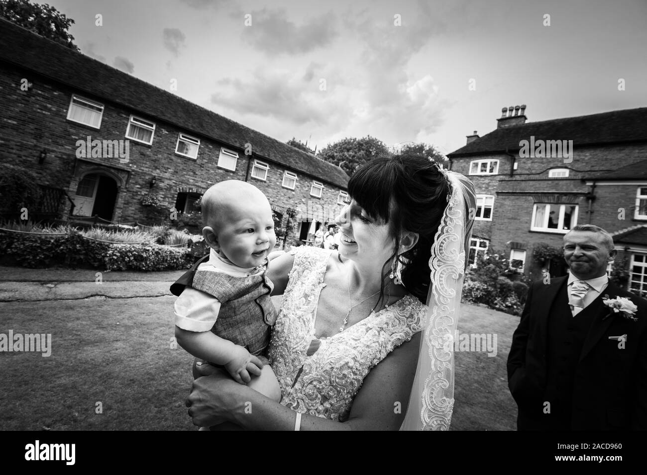 Eine Braut, Mutter posiert mit ihrem kleinen Jungen, nachdem sie geheiratet hat in The Manor Gardens, Hotel, B&B in Cheadle, Stoke on Trent, Staffordshire, Hochzeitstag Stockfoto