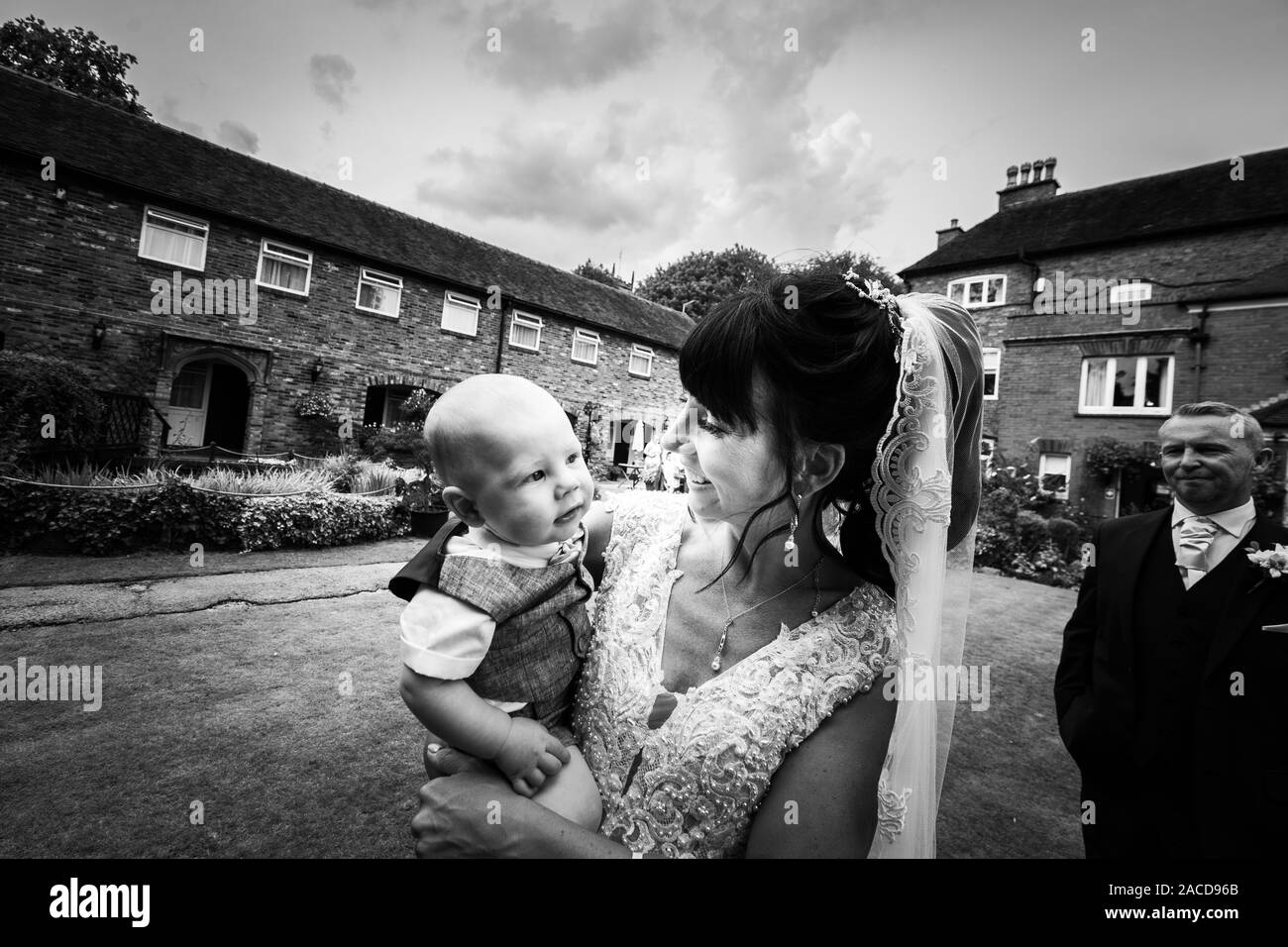Eine Braut, Mutter posiert mit ihrem kleinen Jungen, nachdem sie geheiratet hat in The Manor Gardens, Hotel, B&B in Cheadle, Stoke on Trent, Staffordshire, Hochzeitstag Stockfoto