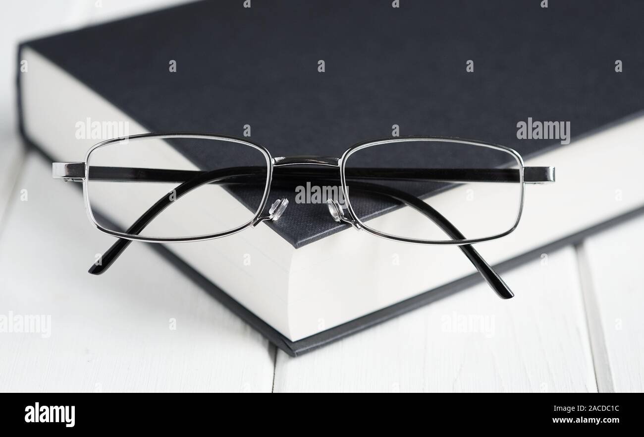 Lesebrille oder Brillen auf gebundenes Buch - Bildung und Wissen Konzept-selektiven Fokus mit flachen deph von Feld Stockfoto
