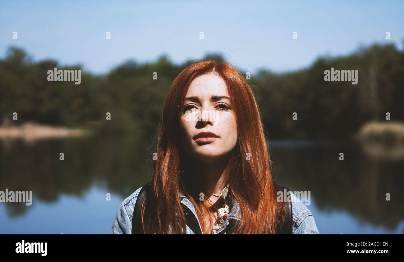 Outdoorsy junge Frau, die von See in grelles Licht mit tiefen Schatten - authentische reale Personen Konzept Stockfoto