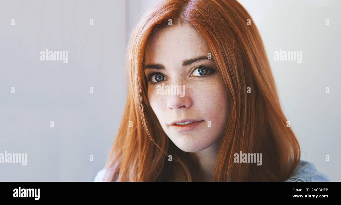 Junge Frau mit roten Haaren und Sommersprossen - rothaarige Mädchen mit freckly oder sommersprossiges Gesicht - indoor Porträt mit Tageslicht Stockfoto