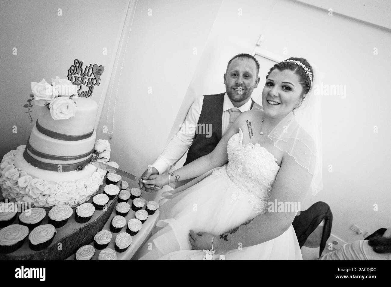Eine sehr glückliche Frau und ein Bräutigam, die nach der großen Zeremonie ihren Hochzeitstorte schneiden! Hochzeitsfotografie, Hochzeitstorte Stockfoto