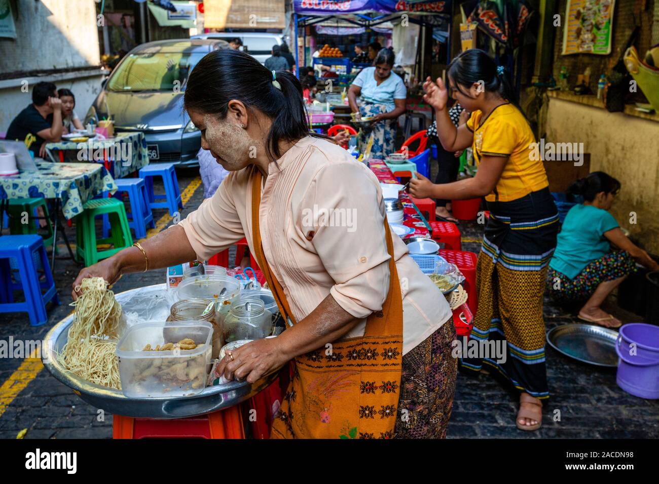 Junge Frauen mit Speisen aus einer Garküche in der Bogyoke Aung San Markt, Yangon, Myanmar. Stockfoto