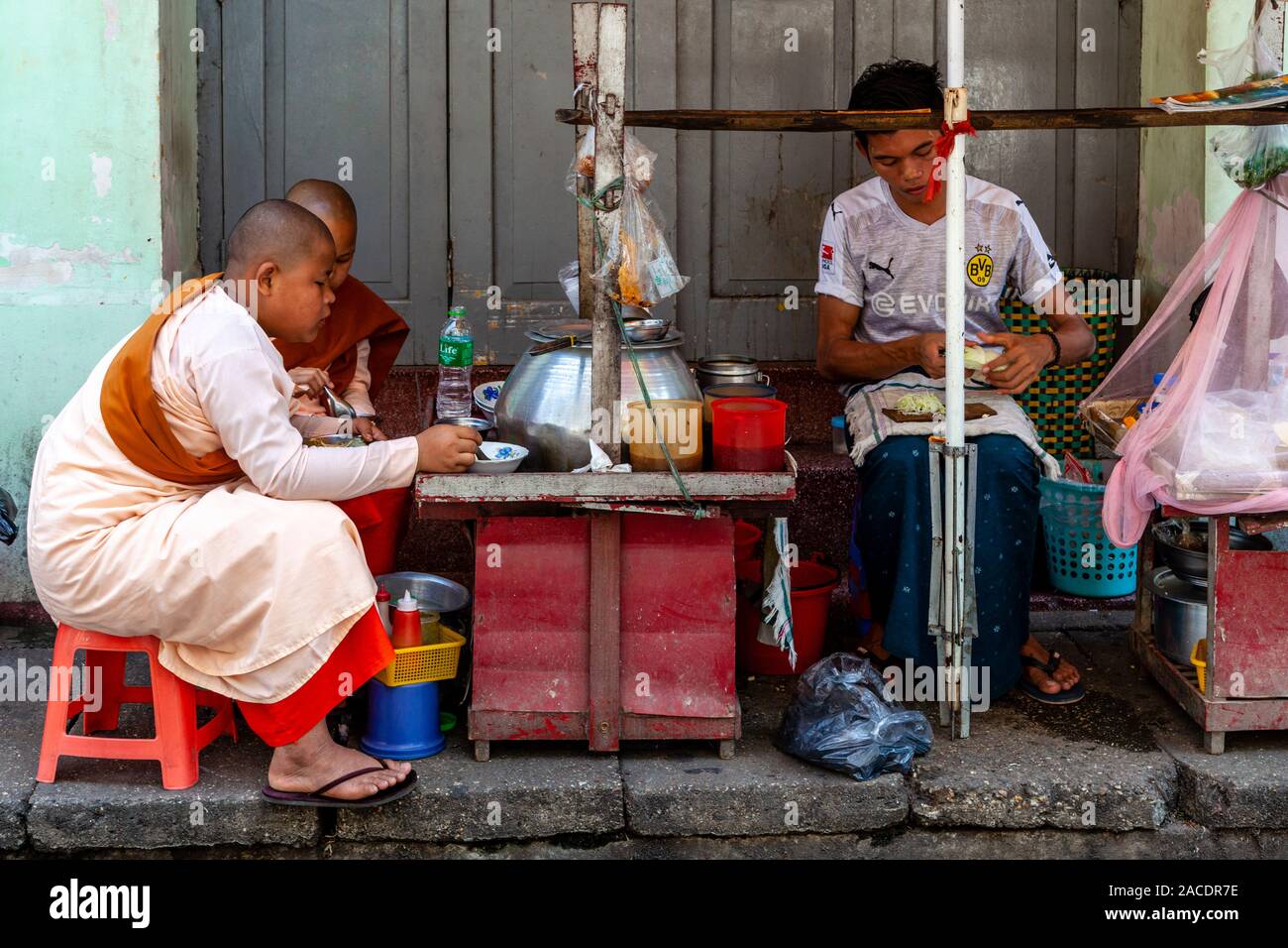 Zwei junge Thilashin (junger buddhistischer Nonnen) Mittagessen an einer Garküche in der Innenstadt von Rangun, Yangon, Myanmar. Stockfoto