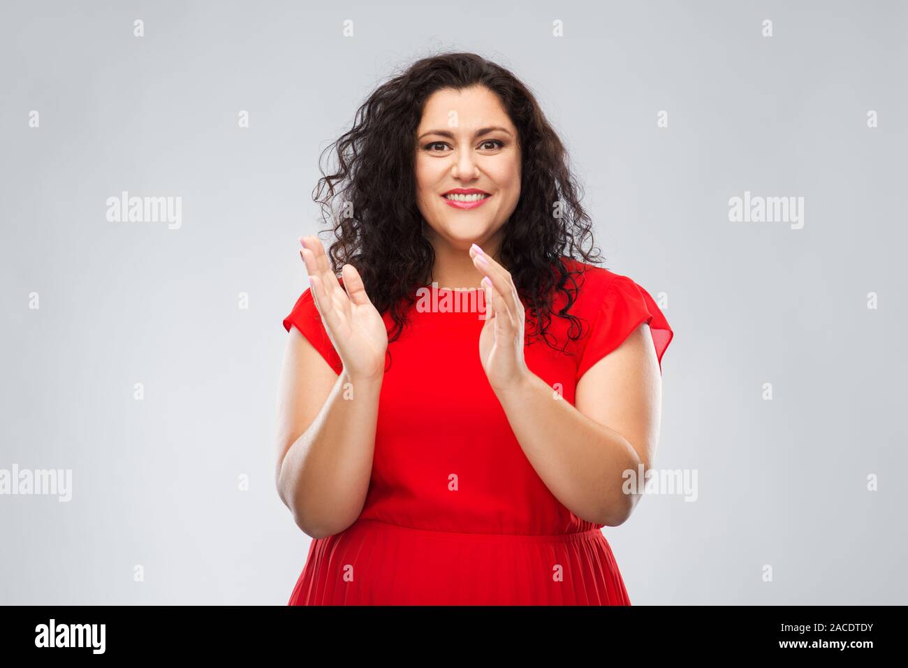 Glückliche Frau im roten Kleid applaudieren Stockfoto