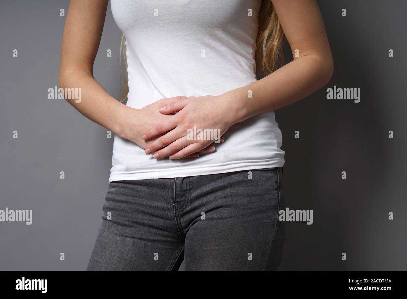 Nicht erkennbare junge Frau Bauch mit beiden Händen - Konzept für dysmenorrhö, Bauchschmerzen, Reizdarmsyndrom, Bauch- oder Magenschmerzen, schmerzliche Perioden oder Krämpfe Stockfoto