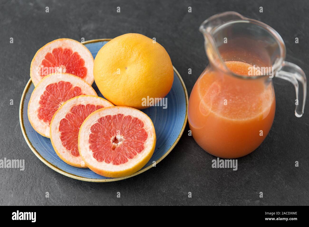 Kanne von Fruchtsäften mit grapefruits auf Platte Stockfoto