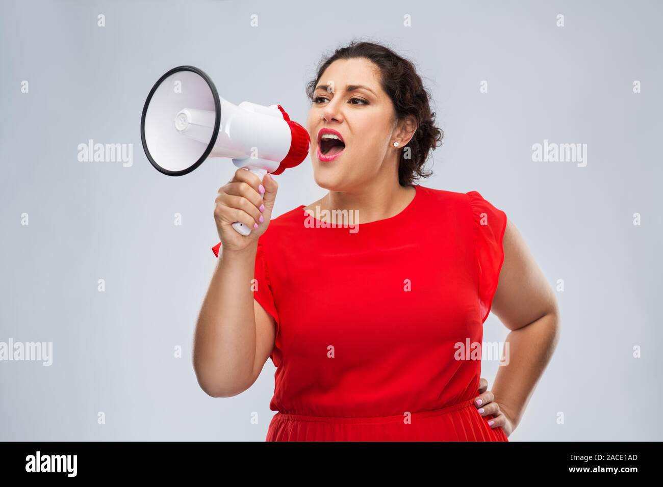Die Frau im roten Kleid mit Megaphon Stockfoto