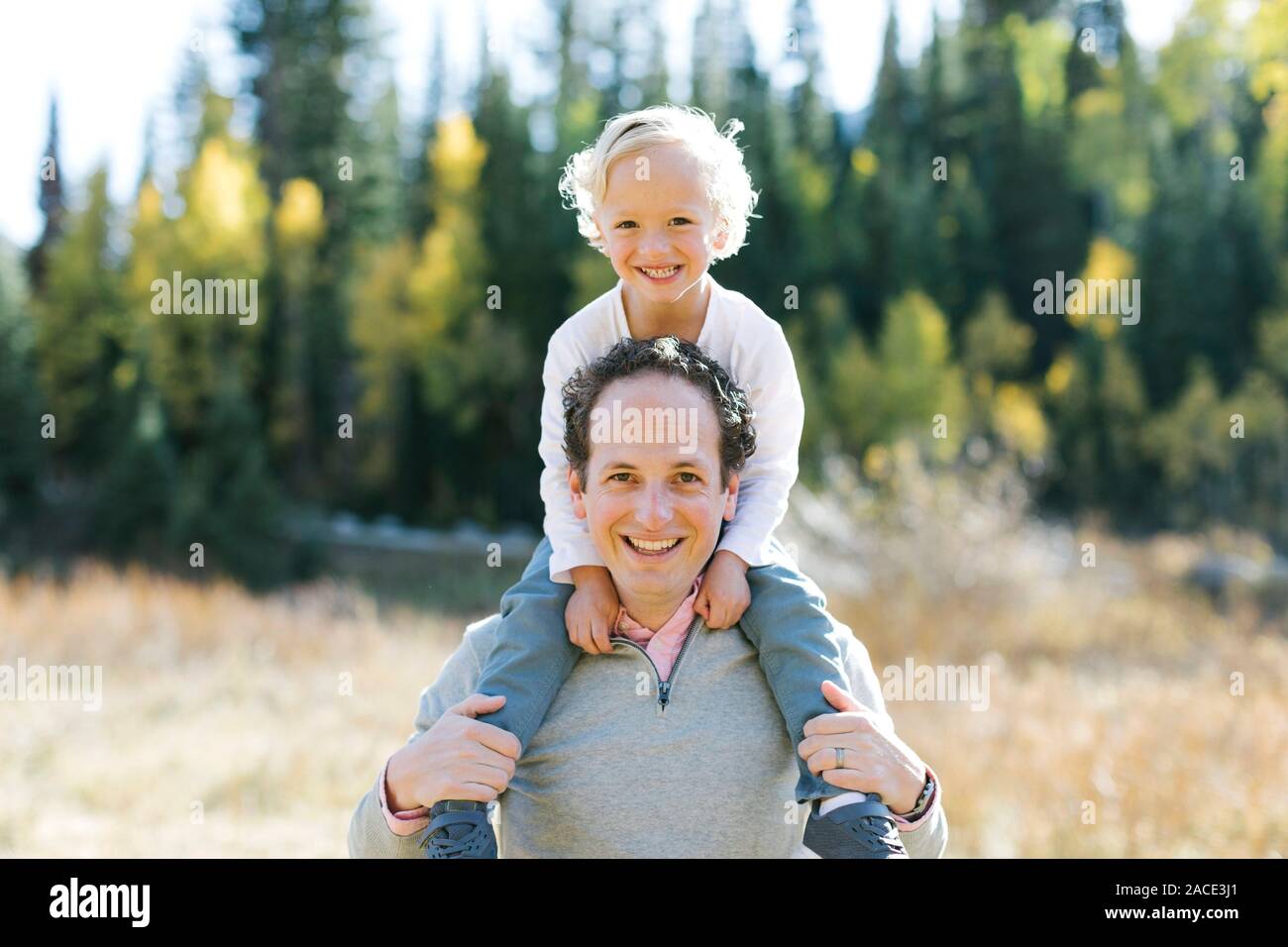 Sohn sitzt auf den Schultern des Vaters in der Natur Stockfoto