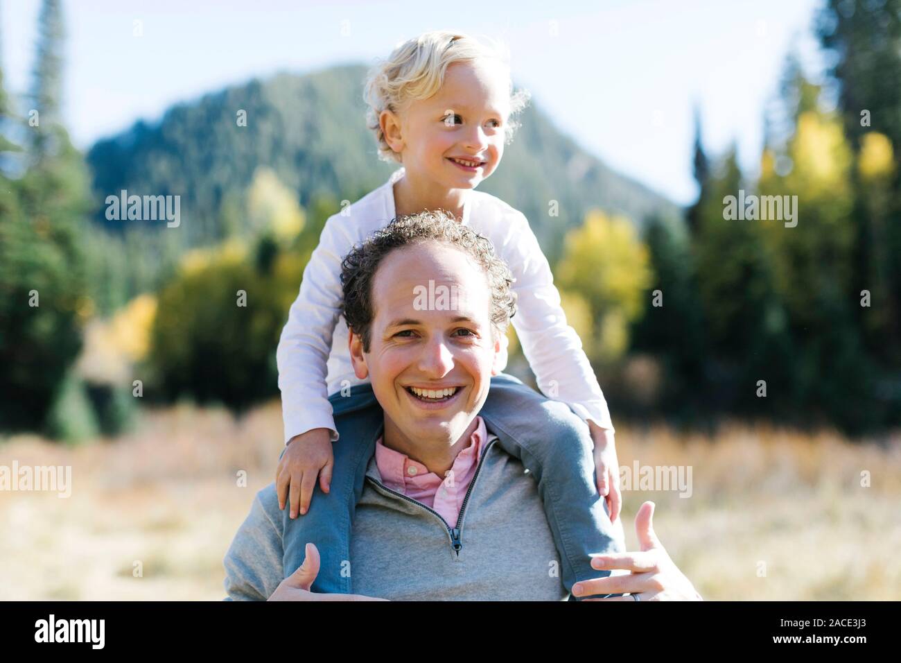 Sohn sitzt auf den Schultern des Vaters in der Natur Stockfoto