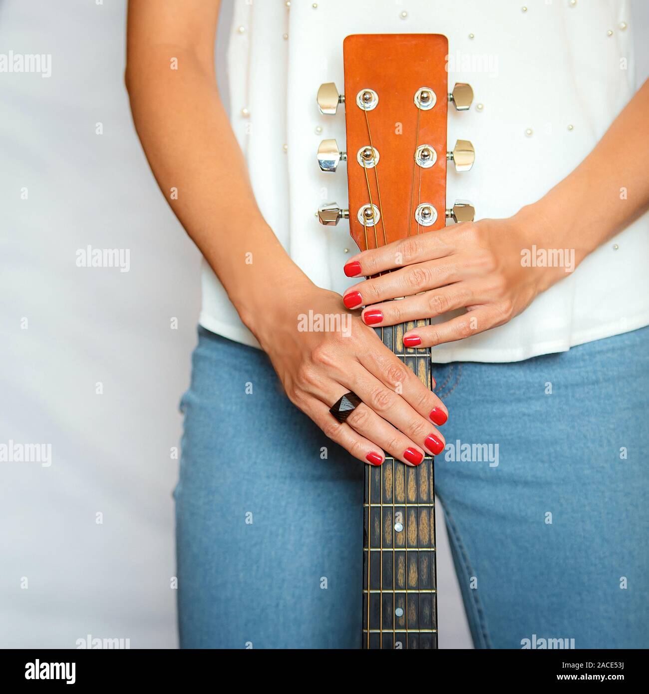 Ist ein Mädchen Hand, mit der Sie eine akustische Gitarre vom Hals halten Stockfoto