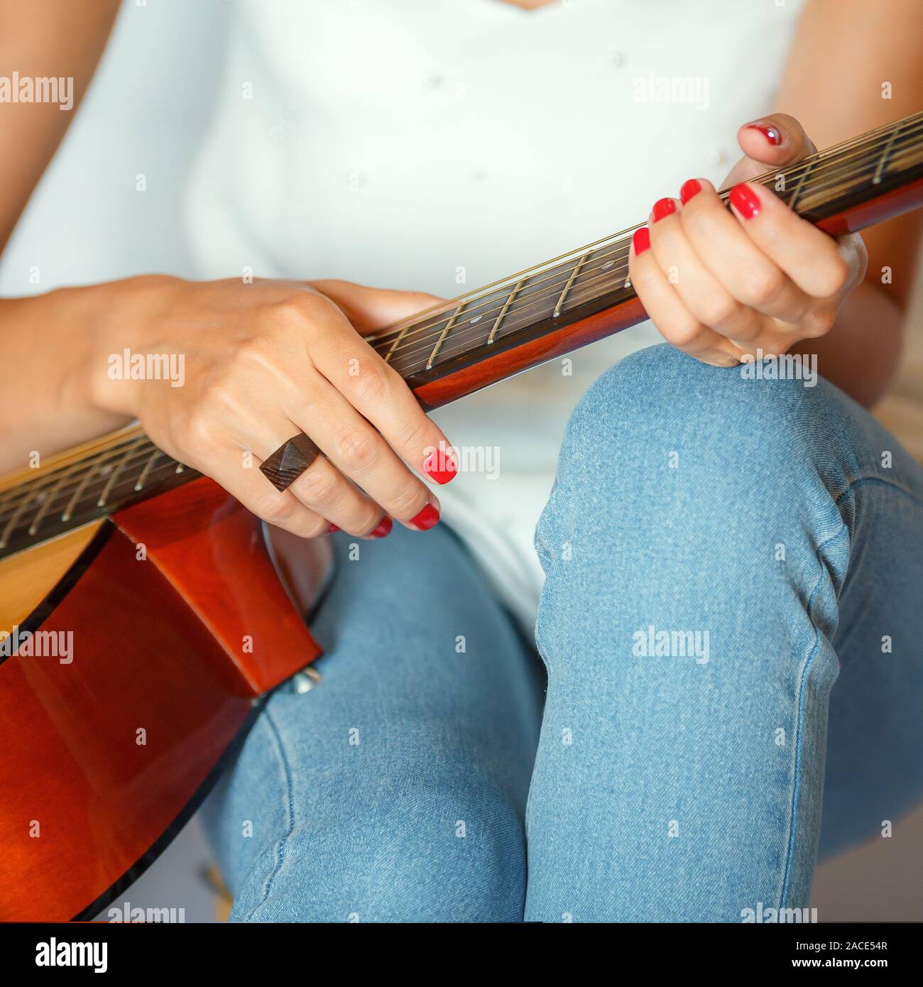 Ist ein Mädchen Hand, mit der Sie eine akustische Gitarre vom Hals halten Stockfoto
