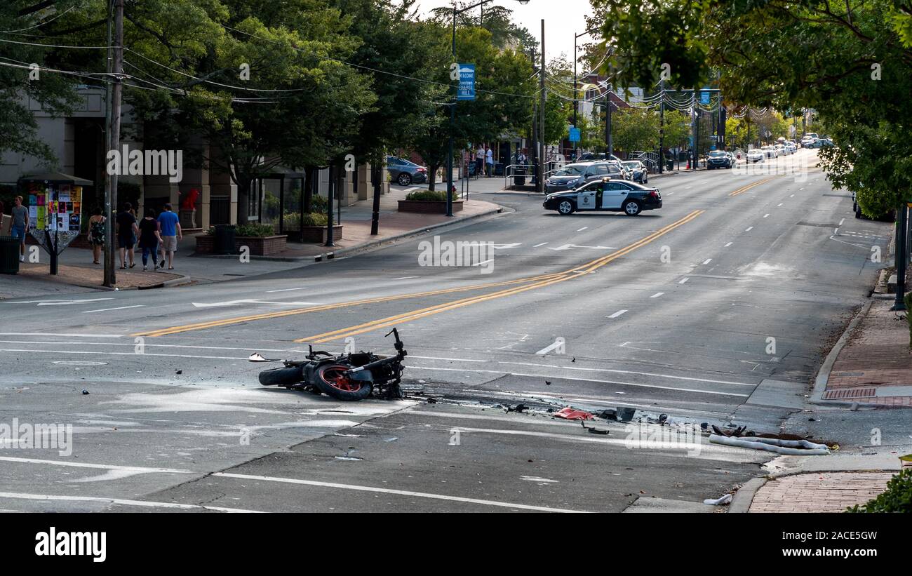 Ruinierte Motorradhalterung bei der Verlegung auf der Straße mit Polizei Auto im Hintergrund nach explodiert in Unfall in Chapel Hill NC Stockfoto