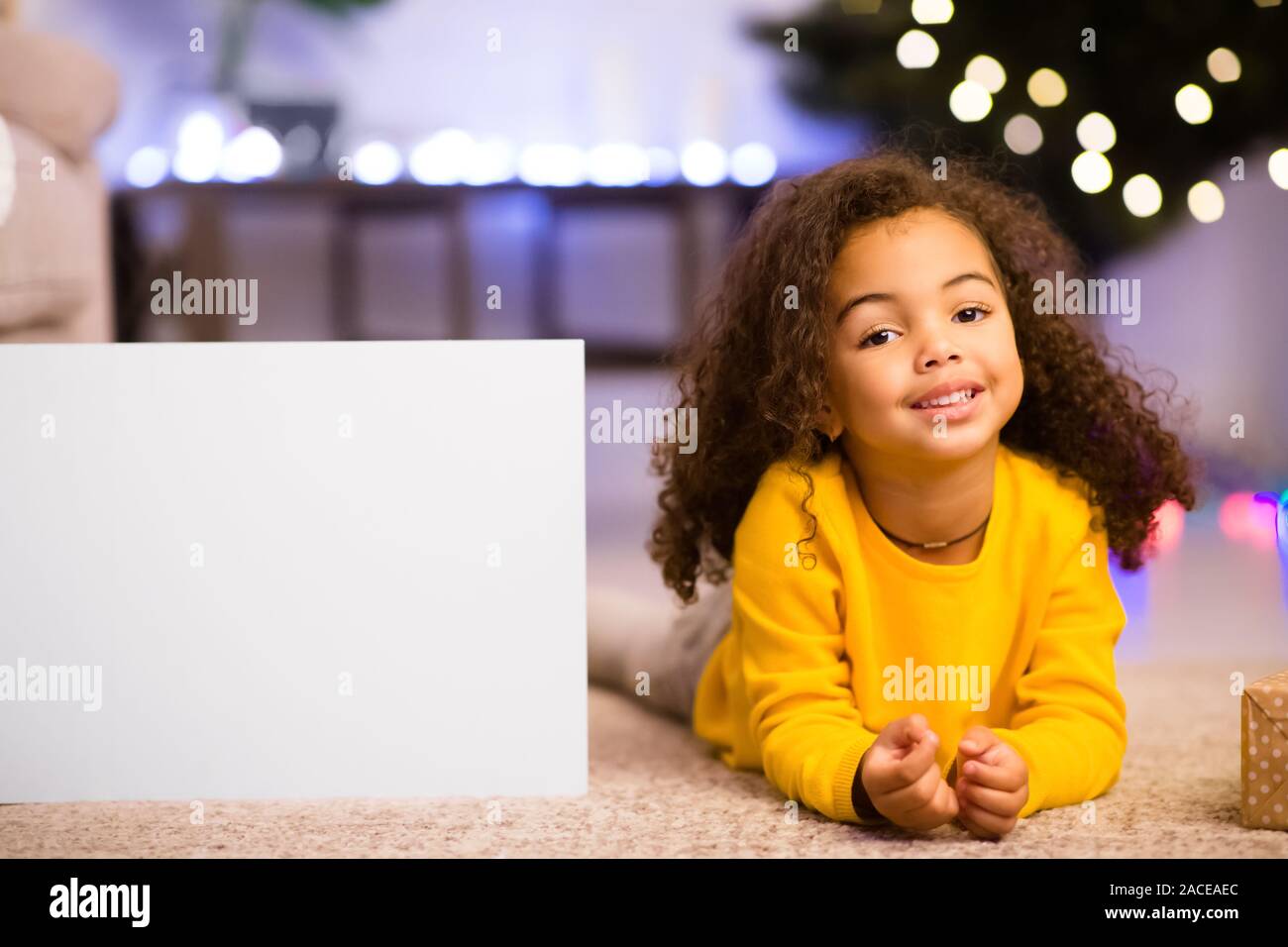 Nett freundlich Afro kleines Mädchen ruht in der Nähe von Super Weihnachtsangebot Stockfoto