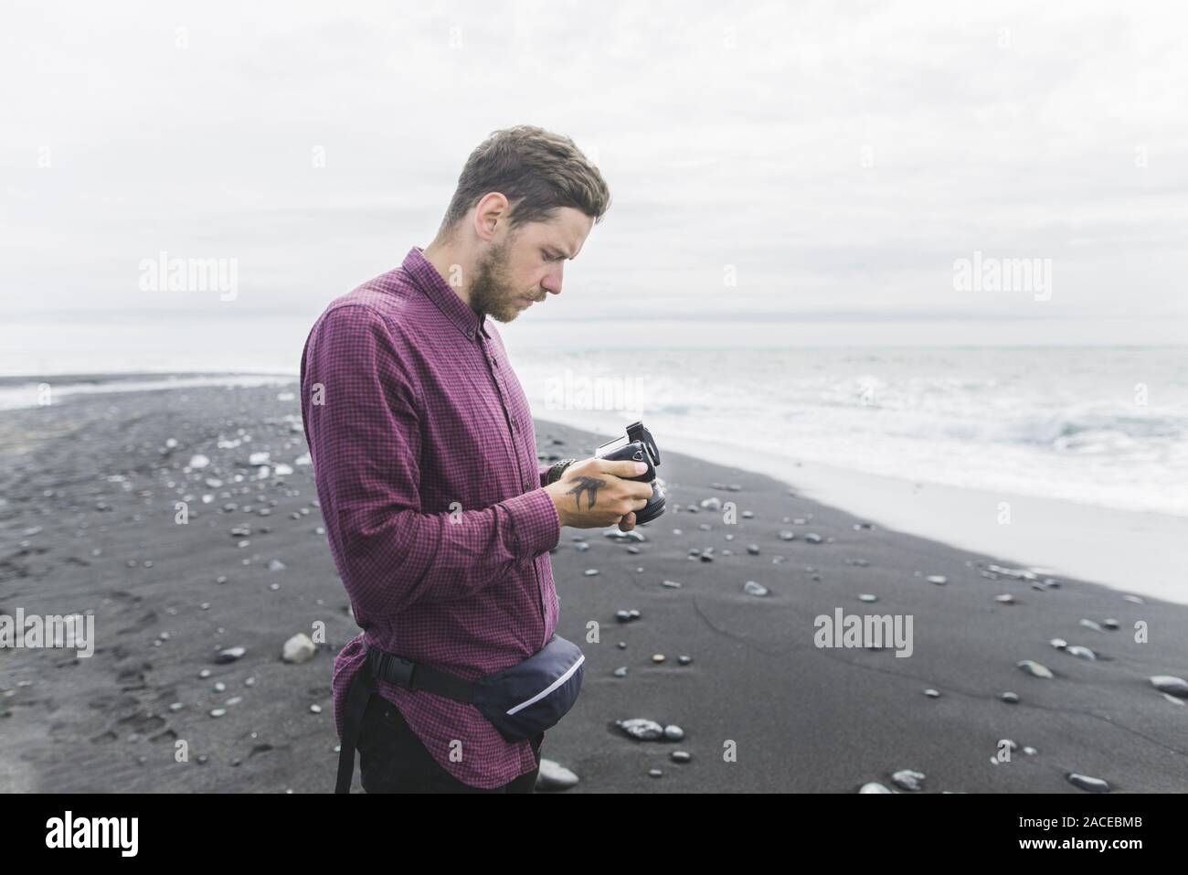 Mann mit Kamera am Strand in Island Stockfoto