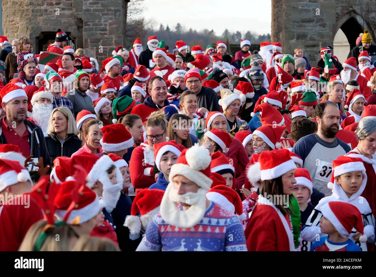 Rund 500 Personen an der Monmouth Santa Fun Run, Start und Ziel am Grenzstein, historische Monnow Bridge am Sonntag, den 1. Dezember. Die Stockfoto