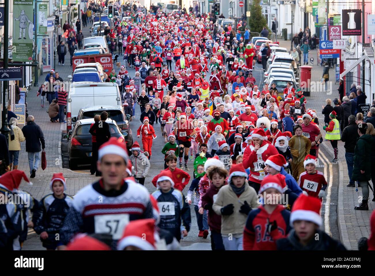 Rund 500 Personen an der Monmouth Santa Fun Run, Start und Ziel am Grenzstein, historische Monnow Bridge am Sonntag, den 1. Dezember. Die Stockfoto