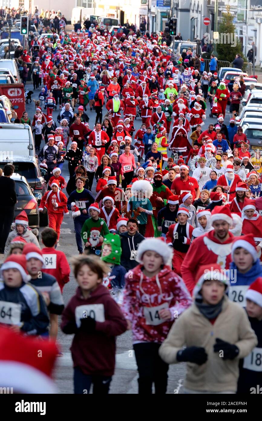 Rund 500 Personen an der Monmouth Santa Fun Run, Start und Ziel am Grenzstein, historische Monnow Bridge am Sonntag, den 1. Dezember. Die Stockfoto