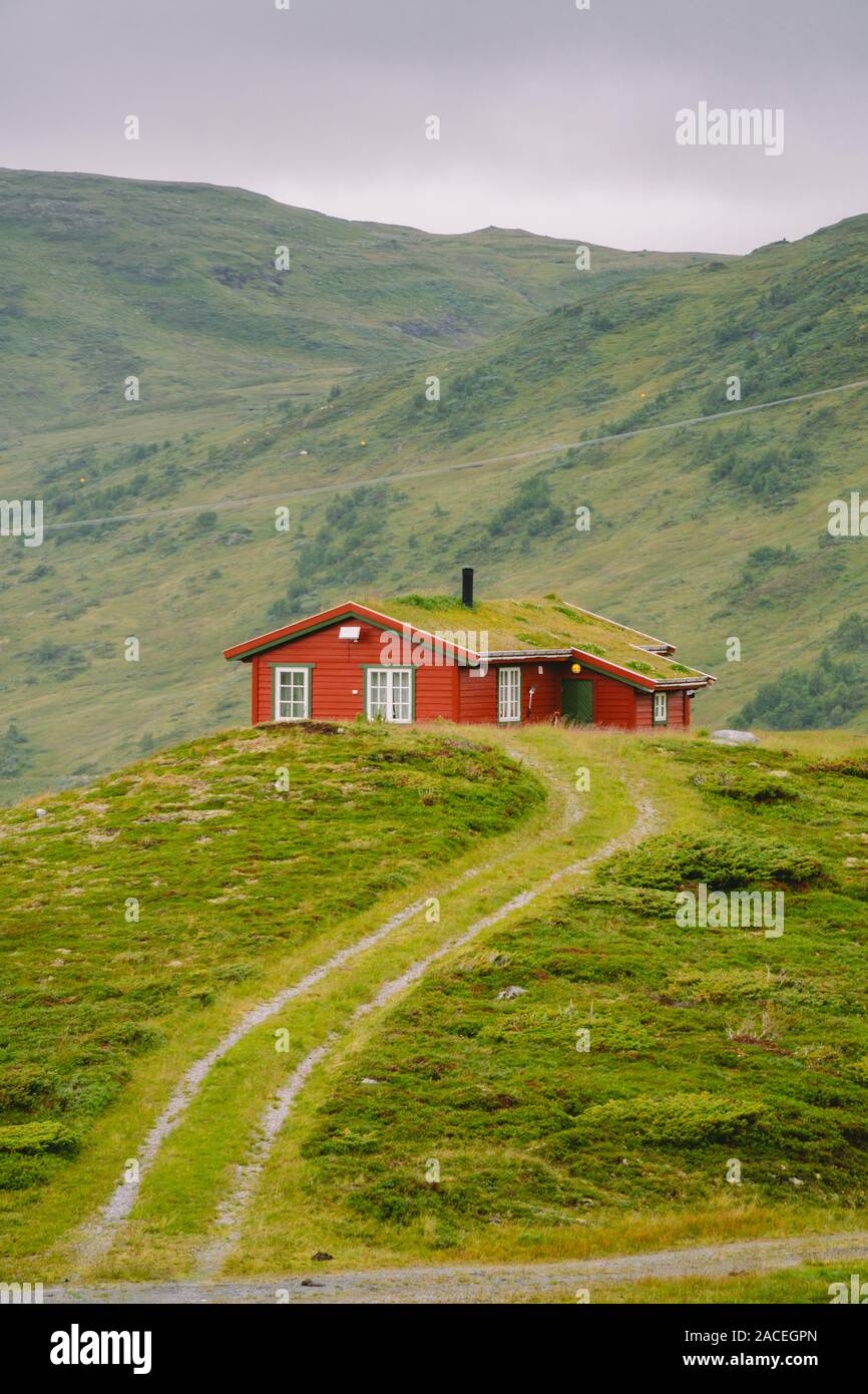 Hütte Holz- Berghütten in Mountain Pass Norwegen. Norwegische Landschaft mit typischen skandinavischen gras dach Häuser. Bergdorf mit kleinen Häusern Stockfoto