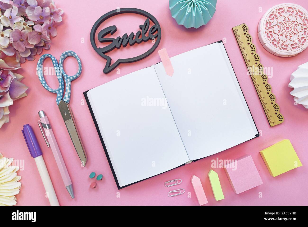 Ansicht von oben flach mit verschiedenen bunten Büromaterial, wie Stifte, Schere, Notizblöcke, Text 'Smile' und öffnen Sie leer Notebook als Platzhalter sagen w Stockfoto