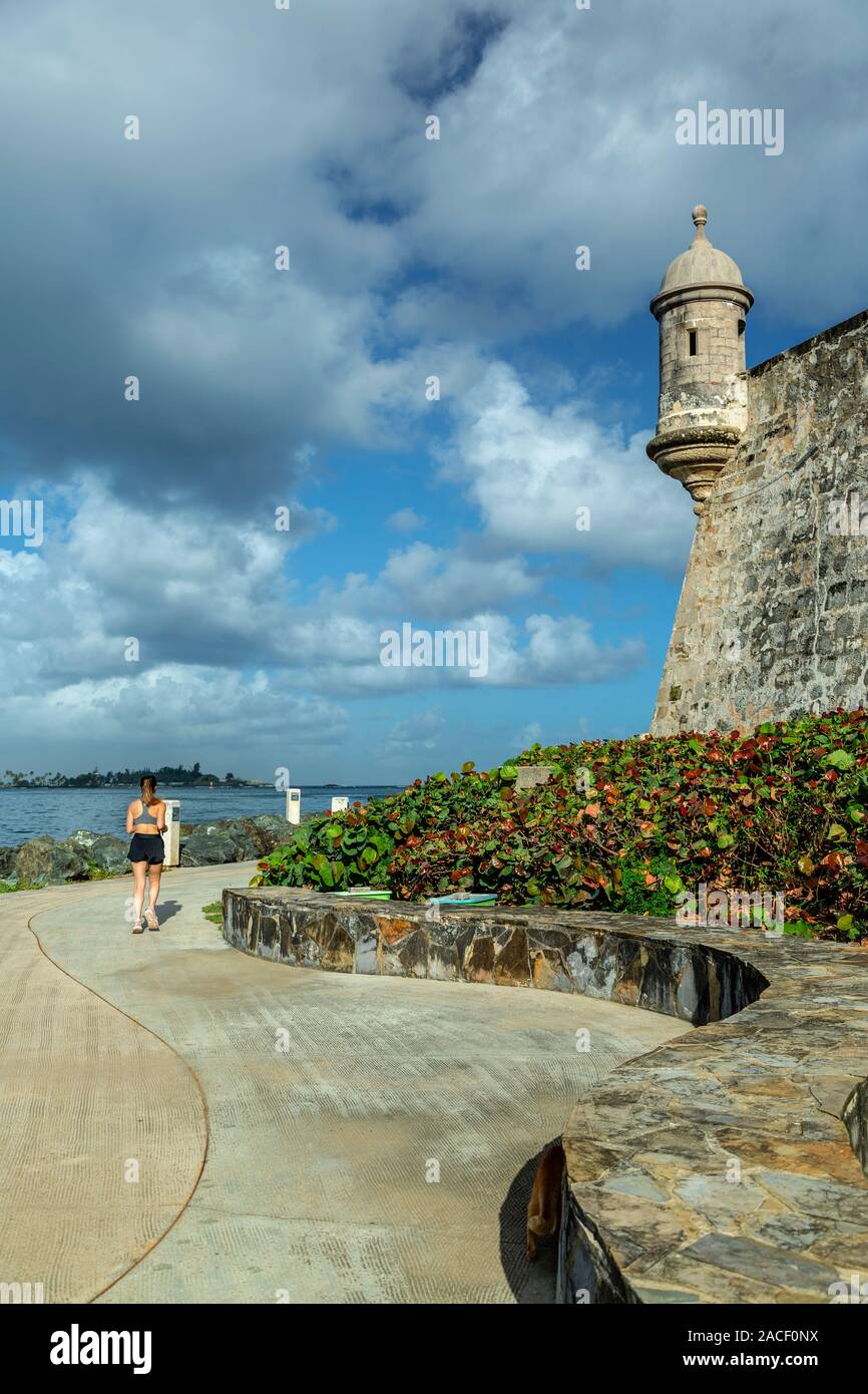 Sentry Haus ('Garita"), Stadtmauer und Frau läuft auf Paseo de La Princesa Trail, San Felipe del Morro Castle (1540s-1786), San Juan National H Stockfoto