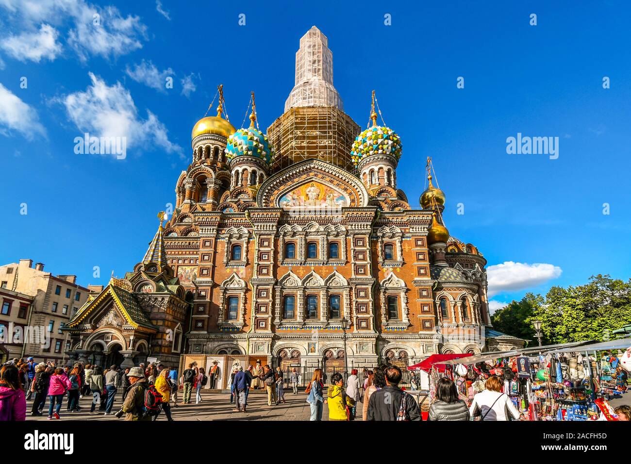 Touristen mischen sich auf dem Platz vor der mittelalterlichen Zwiebeltürmen und Fassade der Kirche des Erlösers auf verschüttetem Blut in St. Petersburg, Russland. Stockfoto
