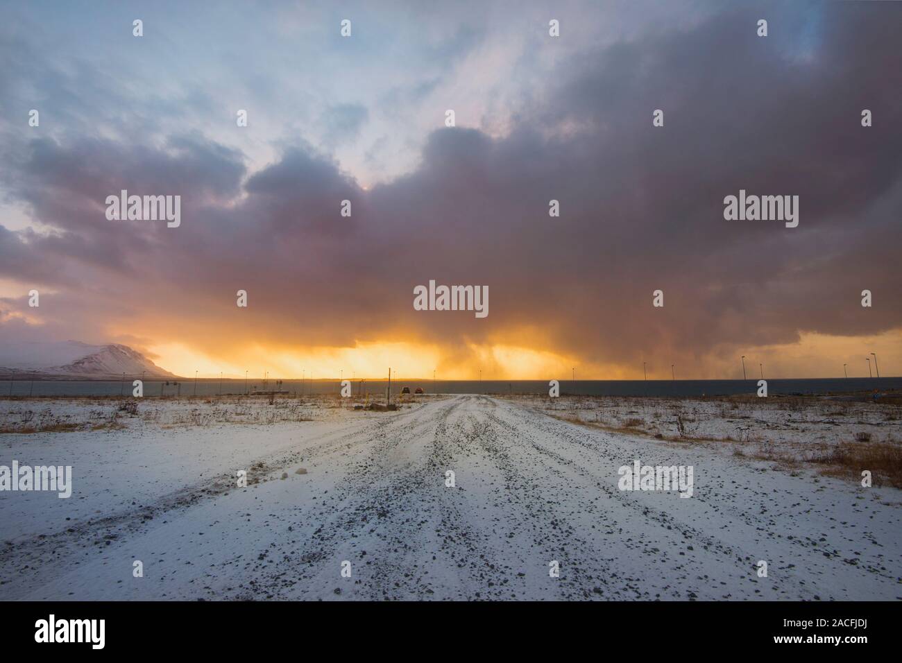 Sie suchen eine Straße in Island, mit einem Sonnenuntergang Himmel auf Feuer und Sturm Wolken Stockfoto