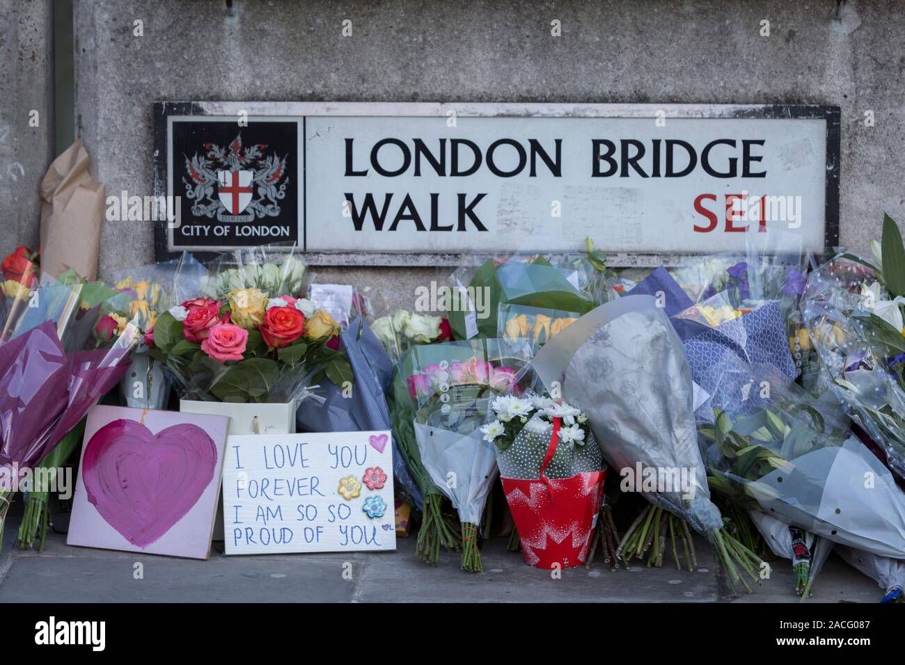 Drei Tage nach der Tötung von Jack Merritt, 25, und Saskia Jones, 23, von der überführten teorrorist Usman Khan an Fischhändler' Hall in London Bridge, ein Denkmal von Blumen an der südlichen (Southwark) Ende der Brücke, wo Passanten und Pendler vorbei auf dem Weg in die Stadt auf der gegenüberliegenden Seite der Themse zu arbeiten, in der City von London, am 2. Dezember 2019 in London, England erschienen. Stockfoto