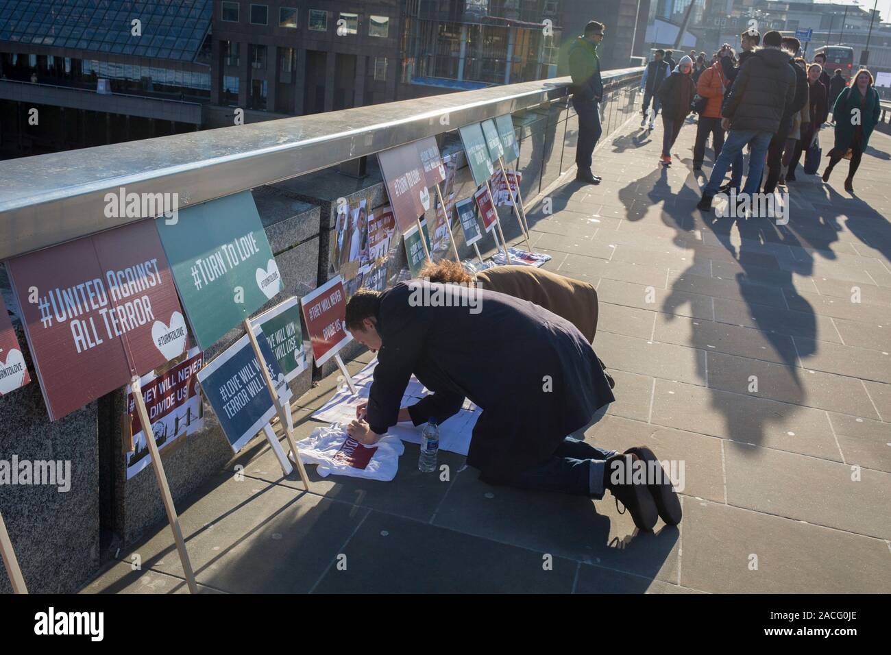 Drei Tage nach der Tötung von Jack Merritt, 25, und Saskia Jones, 23, von der überführten teorrorist Usman Khan an Fischhändler' Hall in London Bridge, ein Denkmal von der multi organisiert - glaube Liebe' Religionen Forum", erschienen auf der Brücke, die die Gesichter der Opfer und ihre Freunde, in der City von London, am 2. Dezember 2019 in London, England. Stockfoto