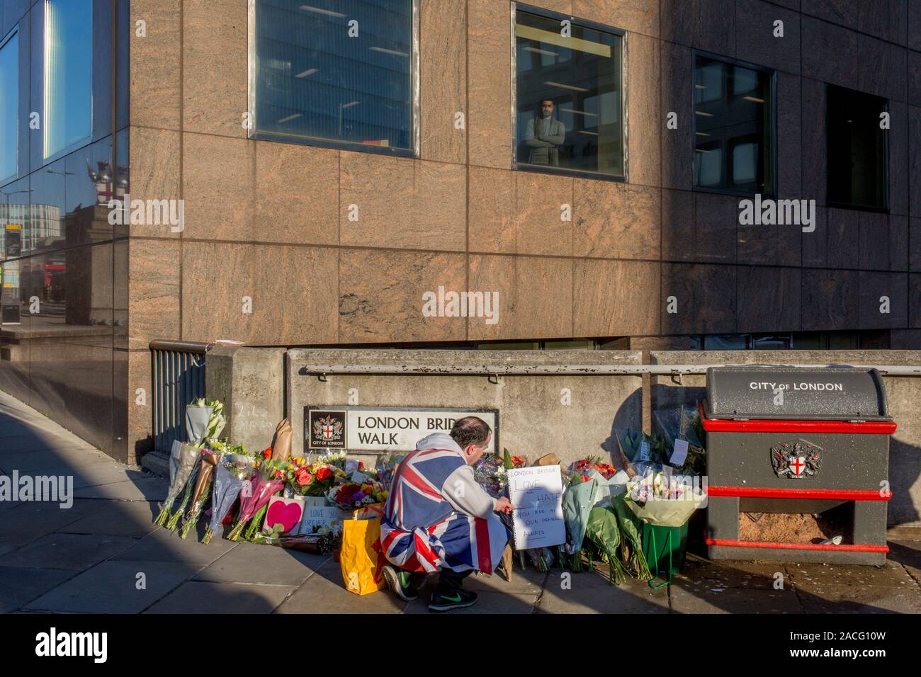 Drei Tage nach der Tötung von Jack Merritt, 25, und Saskia Jones, 23, von der überführten teorrorist Usman Khan an Fischhändler' Hall in London Bridge, ein Denkmal von Blumen an der südlichen (Southwark) Ende der Brücke, wo Passanten und Pendler vorbei auf dem Weg in die Stadt auf der gegenüberliegenden Seite der Themse zu arbeiten, in der City von London, am 2. Dezember 2019 in London, England erschienen. Stockfoto