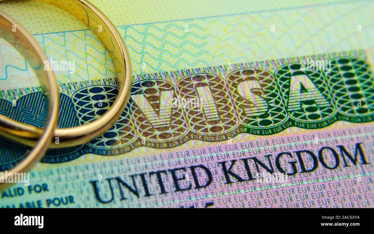 UK Visum Aufkleber in einem Pass und die Ringe oben platziert. Konzept für Partner und Ehepartner Visum GROSSBRITANNIEN. Stockfoto