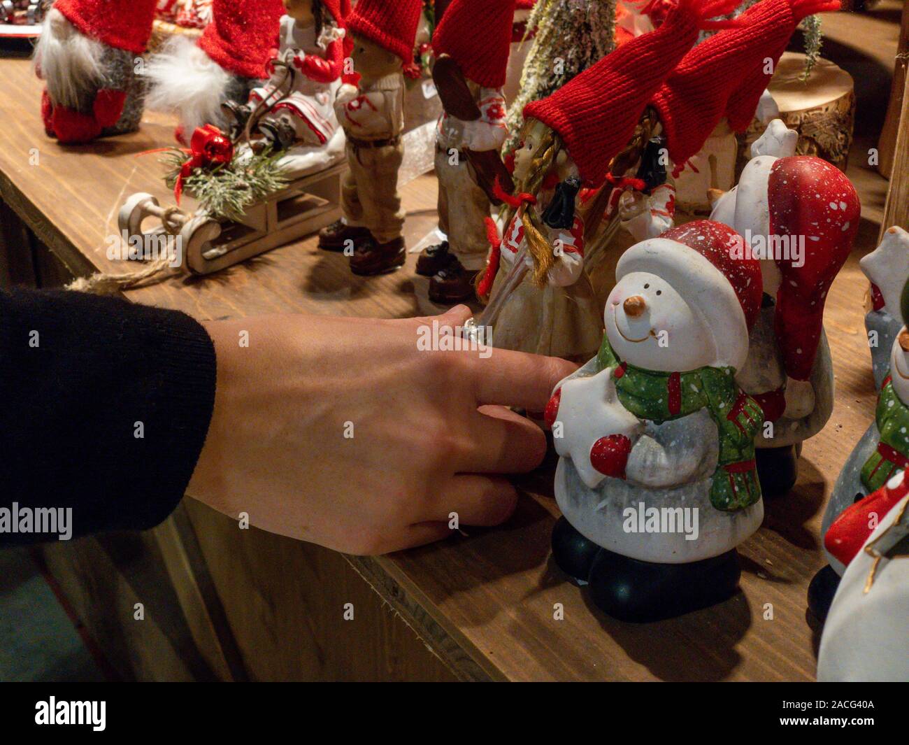 Mailand, Italien - 1. Dezember 2019: Das Mädchen Hand versucht eine Weihnachtsdekoration zu einem Weihnachtsmarkt im Inneren Artigiano in Fiera zu ergreifen, fai Handwerker' Stockfoto