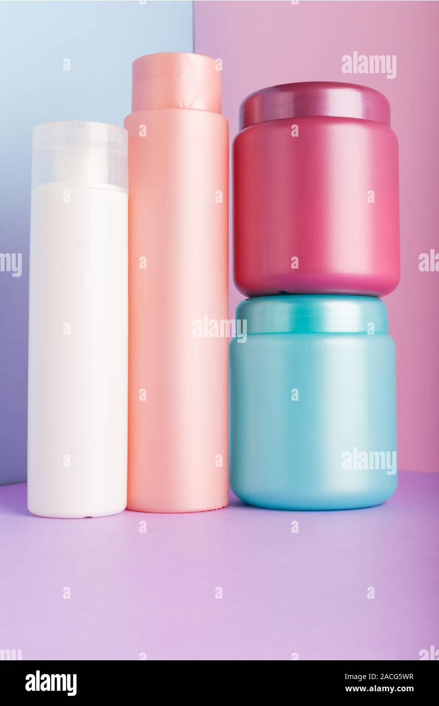 Satz von kosmetischen Produkten auf rosa Hintergrund. Kosmetik Paket Sammlung für Shampoo, Maske, Conditioner, Duschgel. Rosa, Weiß, Blau Kunststoff Flaschen Stockfoto