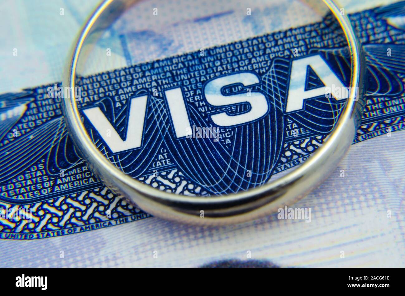 Makro Foto uns Visummarke in einen Reisepass und einen goldenen Ring auf. Konzeptionelle Makro Foto für "den Erhalt der amerikanischen Visa durch die Ehe". Stockfoto