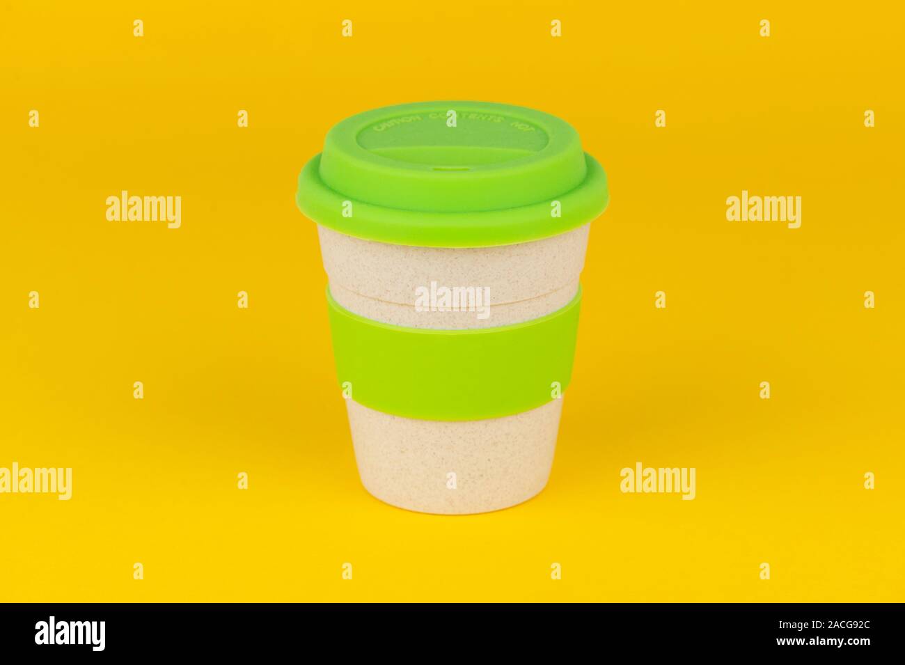 Eine wiederverwendbare Kaffeetasse Schuß auf einen gelben Hintergrund. Stockfoto