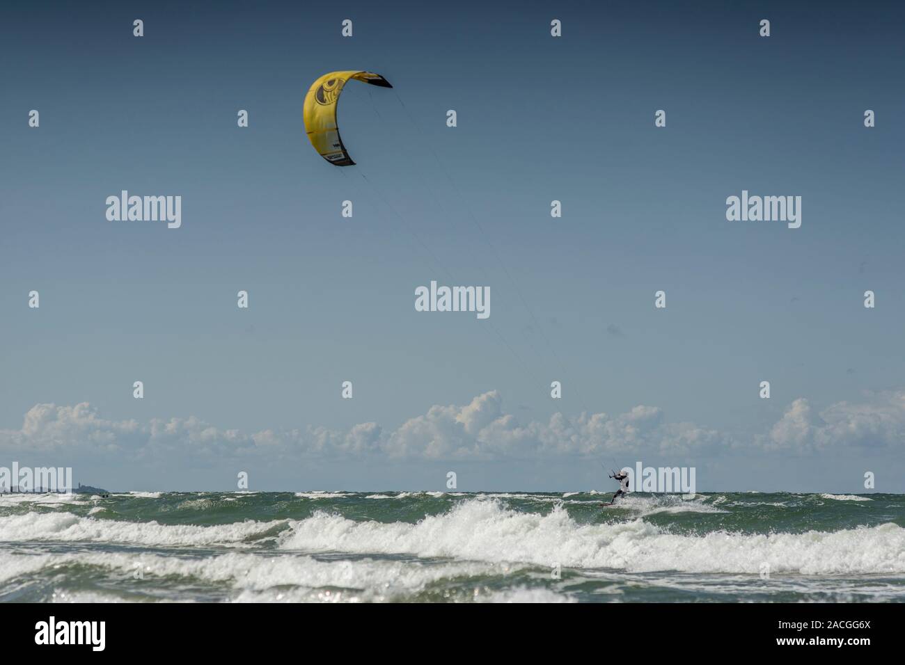 Ein Kite Surfer ist Surfen in den Wellen der Ostsee vor der Küste von Mielno, Polen im Jahr 2019. Stockfoto