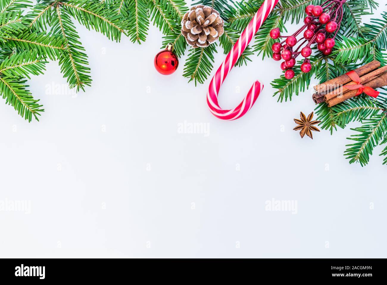 Weihnachten Hintergrund mit Dekorationen, tannenzweigen, Süßigkeiten, rote Beeren, Kegel, Zimt, Anis und Platz für Text. Stockfoto