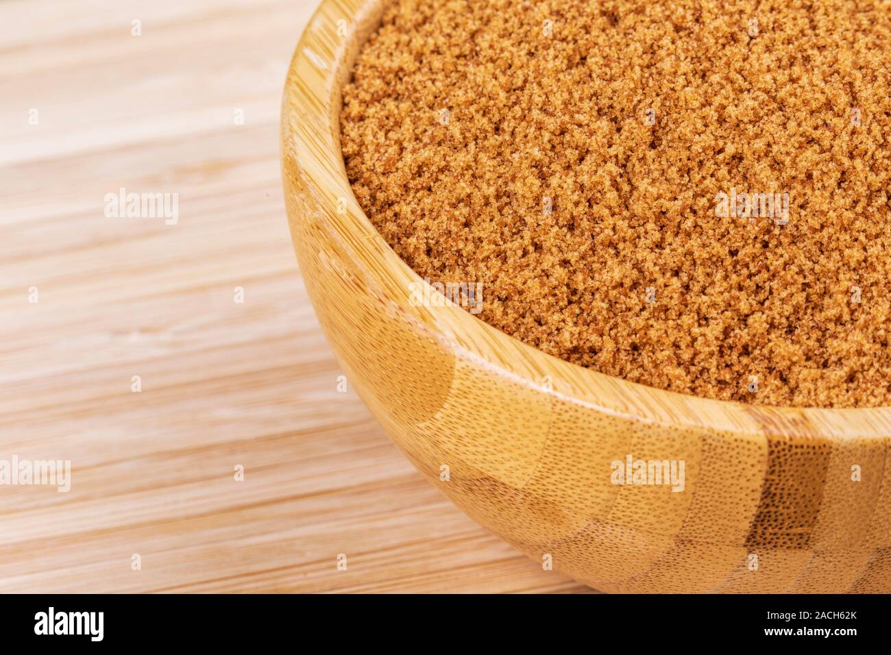 Hölzerne Schüssel voll süßer Hellbraun Zucker auf einer hölzernen Hintergrund Stockfoto