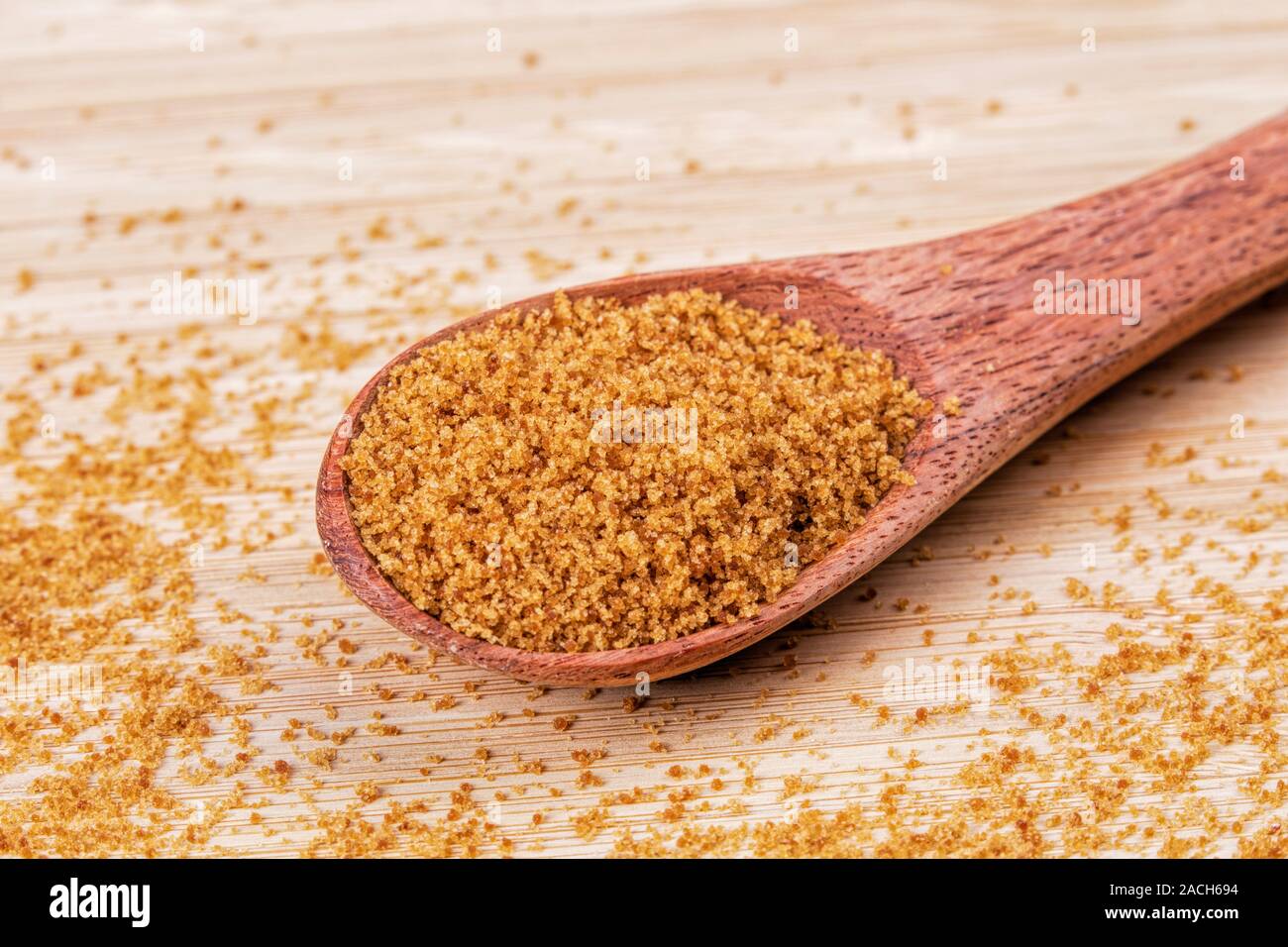 Löffel aus Holz, voll von süßen braunen Zucker auf einer hölzernen Hintergrund Stockfoto