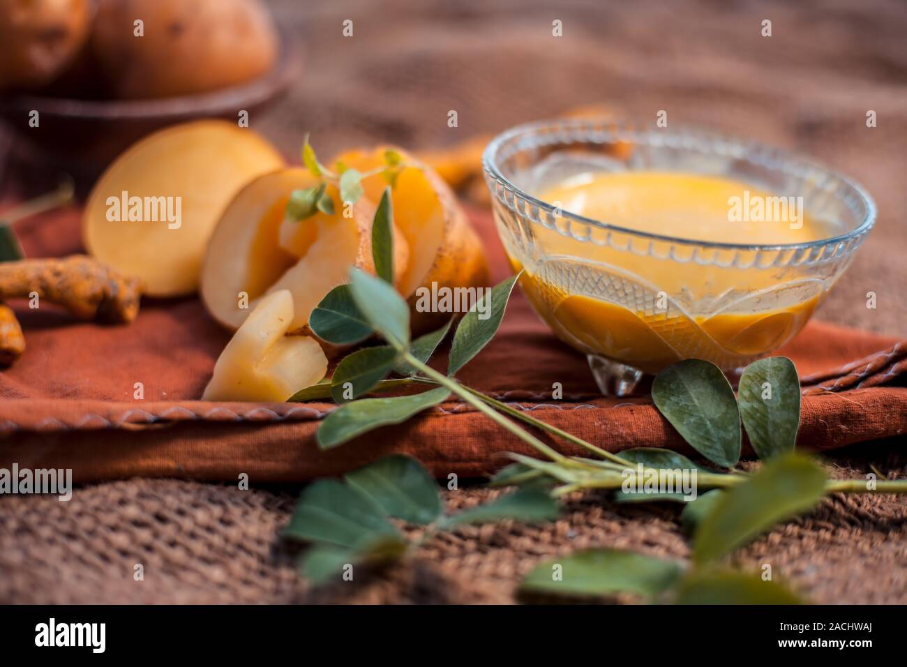 Kartoffel Gesichtsmaske bestehend aus geriebenen Kartoffeln und etwas Kurkuma Pulver oder Haldi in eine Glasschüssel auf jutesäcken Oberfläche die Haut aufzuhellen, tötet bacter Stockfoto
