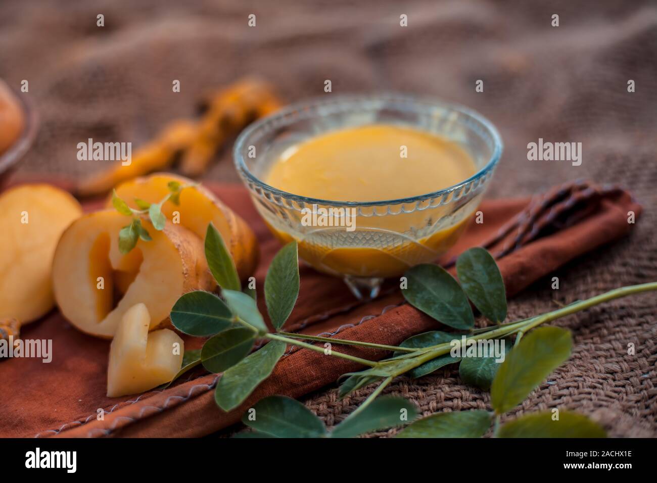 Kartoffel Gesichtsmaske bestehend aus geriebenen Kartoffeln und etwas Kurkuma Pulver oder Haldi in eine Glasschüssel auf jutesäcken Oberfläche die Haut aufzuhellen, tötet bacter Stockfoto