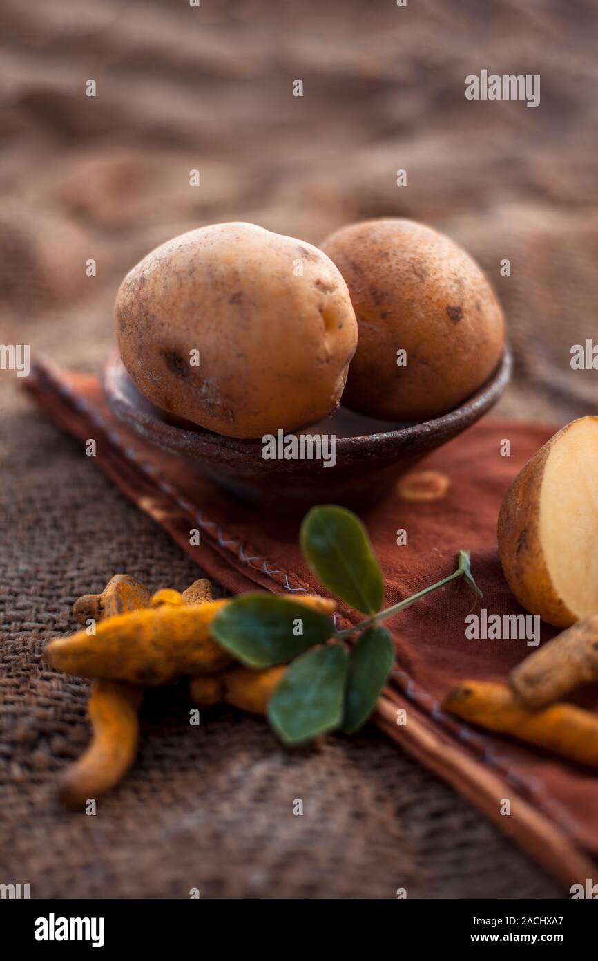 Kartoffel Gesichtsmaske bestehend aus geriebenen Kartoffeln und etwas Kurkuma Pulver oder Haldi in eine Glasschüssel auf jutesäcken Oberfläche die Haut aufzuhellen, tötet bacter Stockfoto