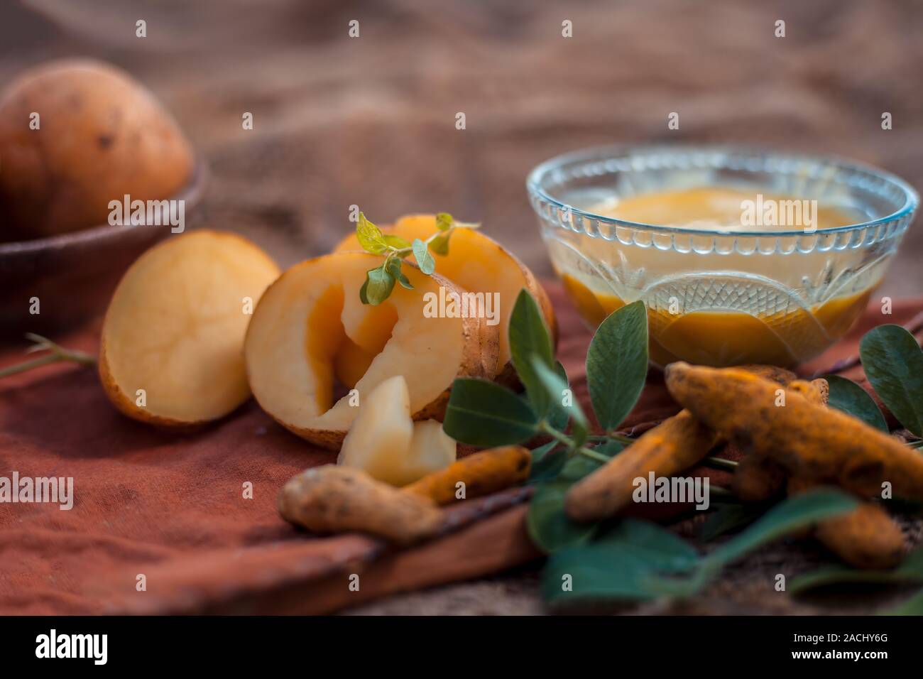 Kartoffel Gesichtsmaske bestehend aus geriebenen Kartoffeln und etwas Kurkuma Pulver oder Haldi in eine Glasschüssel auf jutesäcken Oberfläche die Haut aufzuhellen, tötet bacter Stockfoto