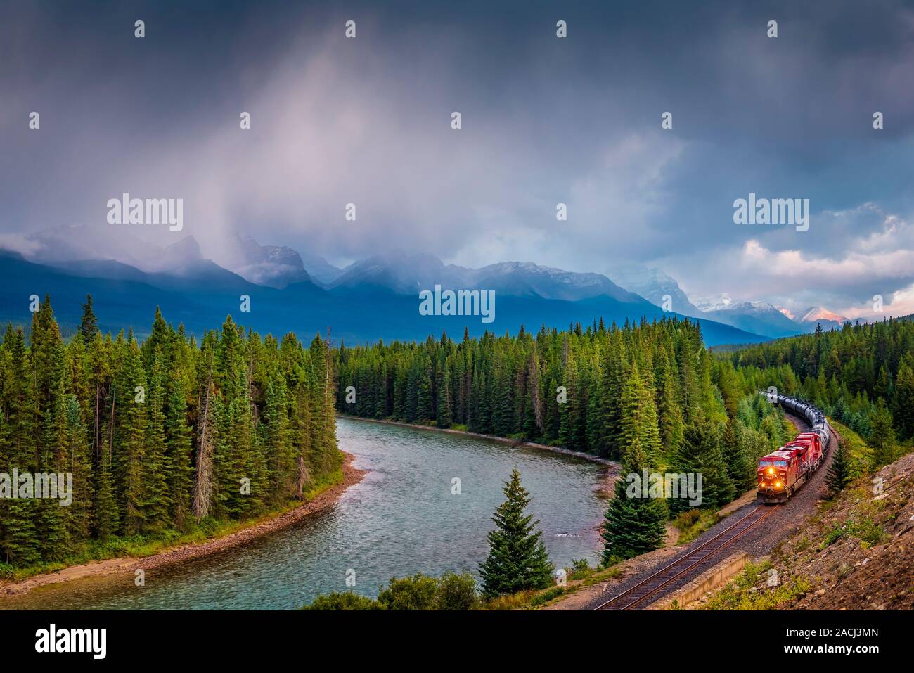 Canadian Pacific Train Coming out of a Curve with Storm Clouds, Banff National Park, Alberta, Kanada. Stockfoto