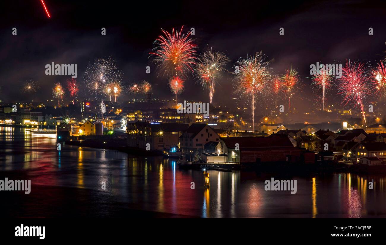 Feuerwerk über der Stadt, die durch das Meer an Silvester. Stockfoto